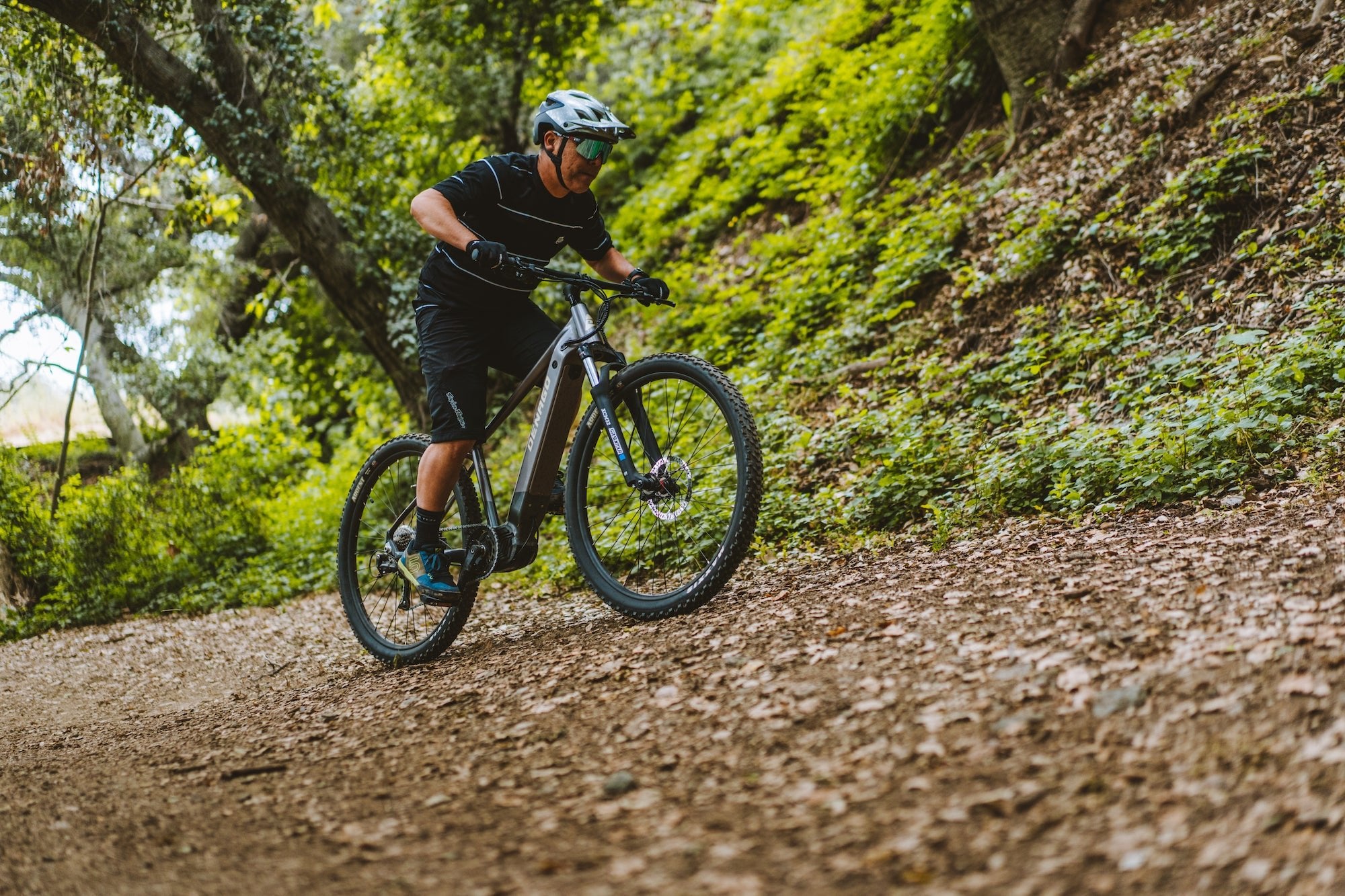 Photograph of a man riding the Denago eXC1 electric mountain bike