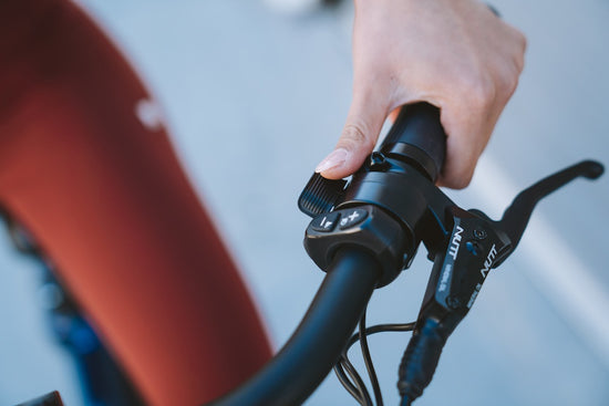 Woman's hand on the throttle of an eBike with safety features called Throttle After Pedal (TAP)