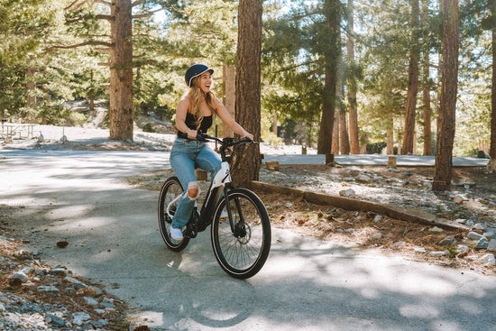 Smiling woman with an eBike in the forest